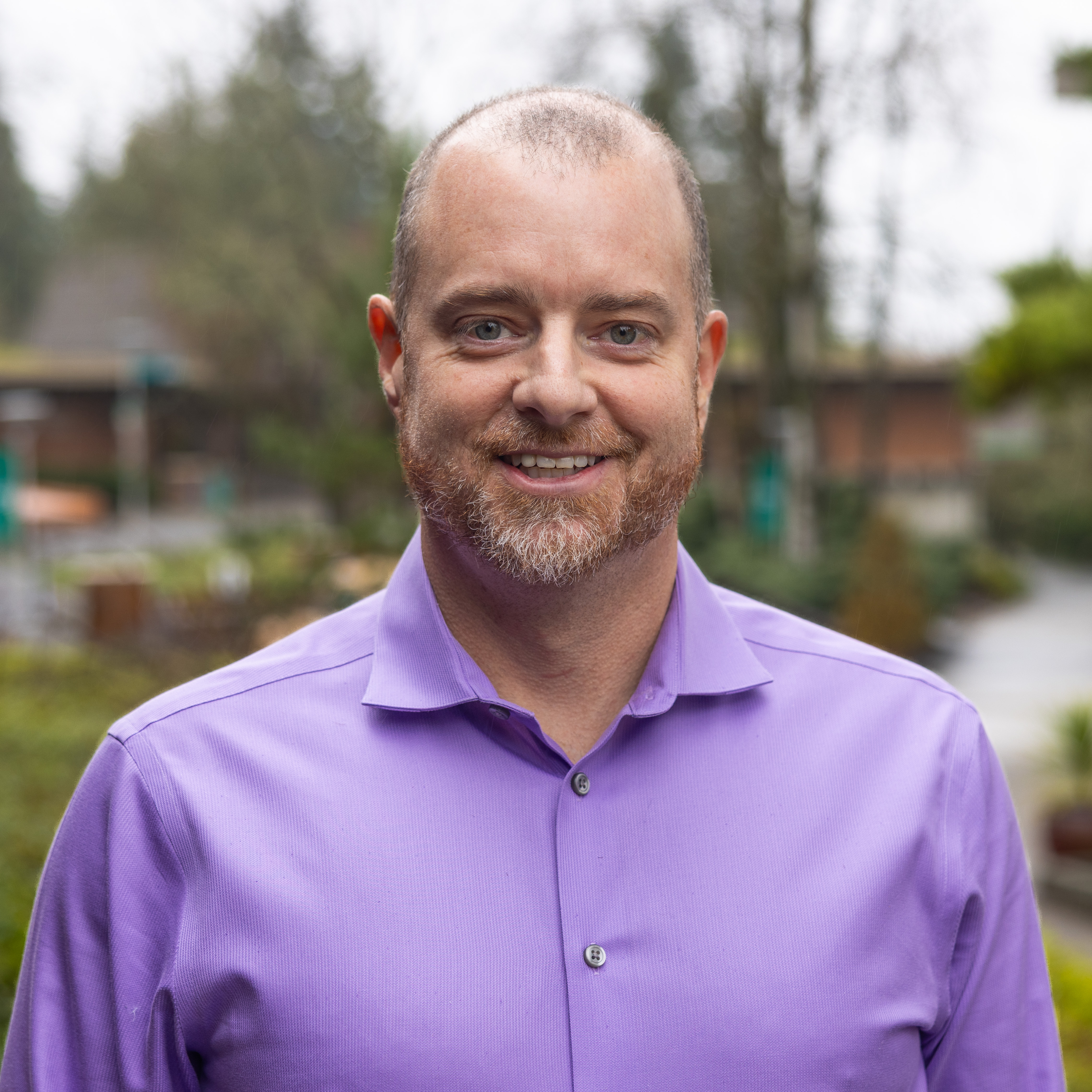 This is a headshot of alumni Ben Slusser wearing a lavender shirt.